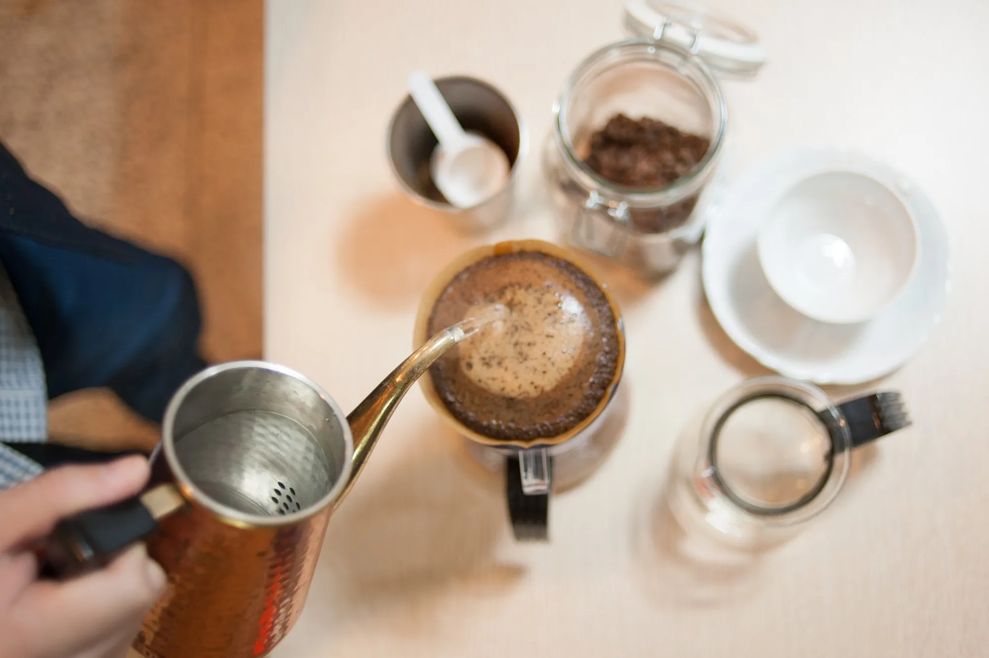 Hot water poured from a gooseneck kettle into a pour-over dripper